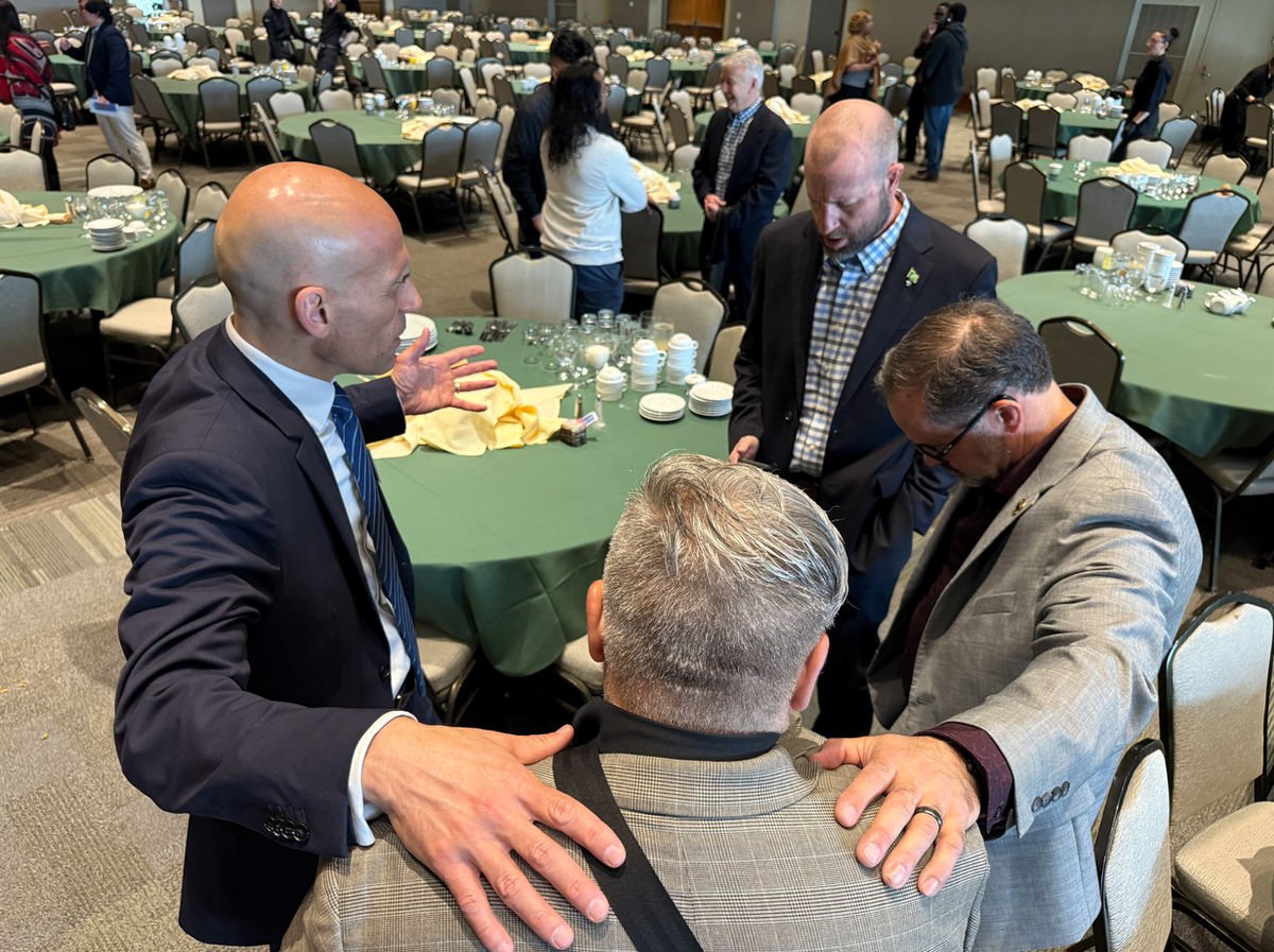 Guests praying together at a breakfast table